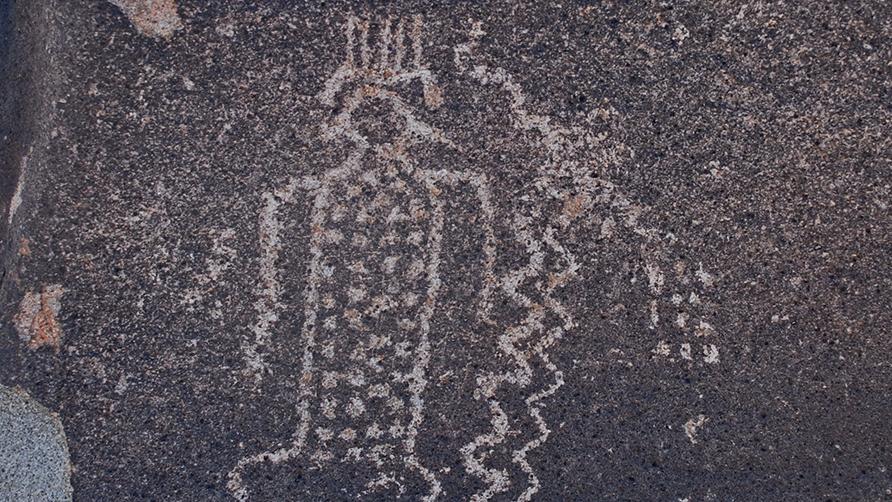 Petroglifo de figura antropomorfa con tocado y cuerpo decorado