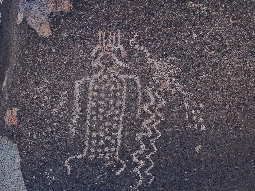 Petroglifo de figura antropomorfa con tocado y cuerpo decorado