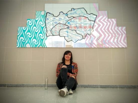 La artista Evelin Contreras junto a su creación instalada en el hospital